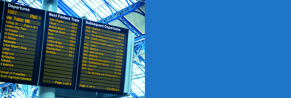 Picture of electronic arrivals and departure board for trains at station.