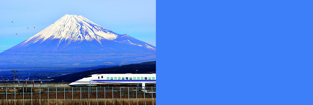 Bullet train passing through Japanes countryside with Mount Fuji in background.