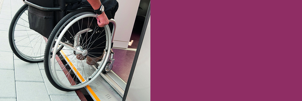 Wheelchair user negotiating door system onto train.